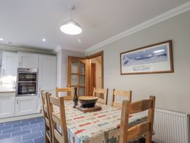 A kitchen with a dining table and chairs at Burnside House in Aviemore