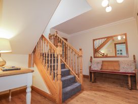 A hallway with a staircase and a bench at Burnside House in Aviemore