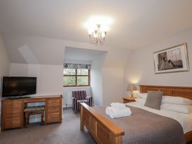 A bedroom with a bed and a television at Burnside House in Aviemore