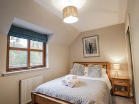 A bedroom with a bed and window at Burnside House in Aviemore