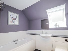 A bathroom with a bathtub and sink at Burnside House, Aviemore