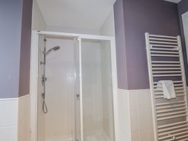 A bathroom with a shower and towel rack at Burnside House in Aviemore