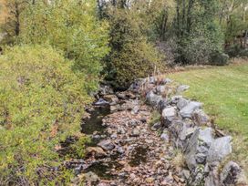 A stream surrounded by rocks and vegetation at Burnside House in Aviemore