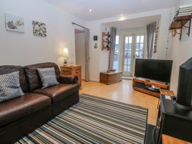 A living room with a television and sofa at Bwthyn Llechen in Porthmadog