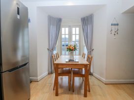 A dining room with a table and chairs at Bwthyn Llechen in Porthmadog