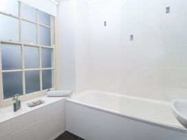 A bathroom with bathtub and wash basin at Bwthyn Llechen in Porthmadog