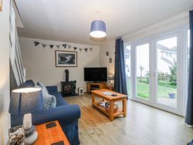 A living room with a sofa and a television at Bwthyn y Mor in Borth-y-Gest near Porthmadog