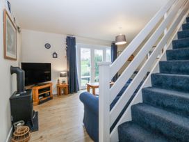 A living room with a television, sofa, and coffee table at Bwthyn y Mor in Borth-y-Gest near Porthmadog