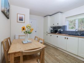 A kitchen with a wooden table and chairs at Bwthyn y Mor in Borth-y-Gest near Porthmadog