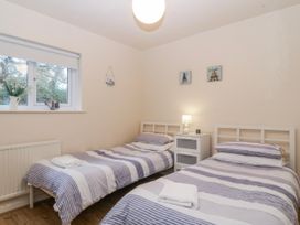 A bedroom with two single beds and a window at Bwthyn y Mor in Borth-y-Gest near Porthmadog