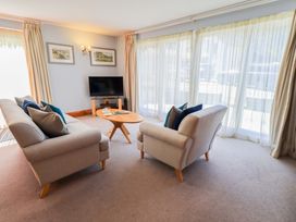 A living room with sofas and a television at Lakeside Cottage Ecclerigg near Ambleside
