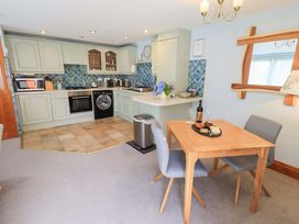 A kitchen with appliances and dining table at Lakeside Cottage Ecclerigg near Ambleside