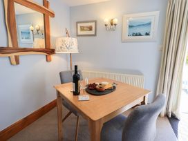 A dining room with a table set with wine and cheese at Lakeside Cottage in Ecclerigg near Ambleside