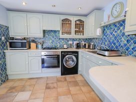 A kitchen with appliances and blue tiled backsplash at Lakeside Cottage in Ecclerigg near Ambleside