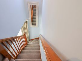 A staircase with a handrail and mirror in Lakeside Cottage Ecclerigg near Ambleside