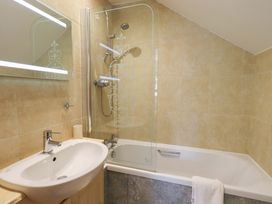 A bathroom with a bathtub and shower at Lakeside Cottage in Ecclerigg near Ambleside