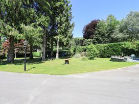 A garden with trees and seating area at Lakeside Cottage in Ecclerigg near Ambleside