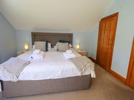 A bedroom with a double bed and bedside lamps at Waterhead Cottage, Ecclerigg, near Troutbeck Bridge