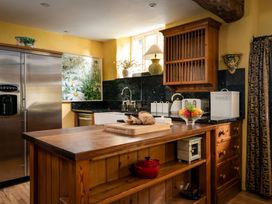 A kitchen with a refrigerator, sink, and a kitchen island at The Meeting House in Ashburton