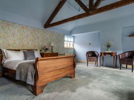 A bedroom with a bed and wooden furniture at The Meeting House in Ashburton