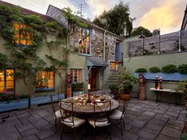 An outdoor dining area with a table and chairs at The Meeting House in Ashburton