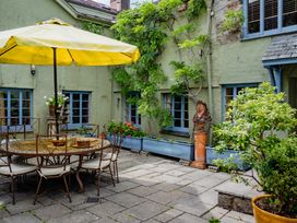 A garden with a table and umbrella at The Meeting House in Ashburton