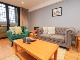 A living room with a sofa, armchair, coffee table, and mugs at Premier, Transit & Lady Hilda @ Engine Shed, Whitby