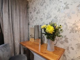 A dining room with a table, flowers in a vase, and a mirror at Premier, Transit & Lady Hilda @ Engine Shed, Whitby