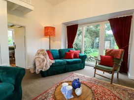 A living room with a green sofa and coffee table at Ael Y Bryn in Menai Bridge