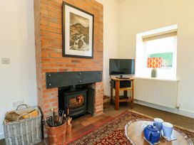 A living room with a fireplace and television at Ael Y Bryn in Menai Bridge