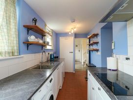 A kitchen with shelves and appliances at Ael Y Bryn in Menai Bridge