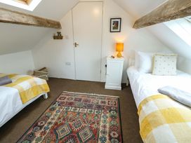 A bedroom with two beds and a table lamp at Ael Y Bryn Menai Bridge