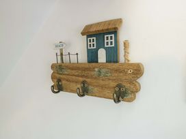 A hook rack with a beach house design and hooks at Ael Y Bryn Menai Bridge