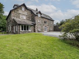 A stone house with a grassy area and parking at High Spy in Keswick