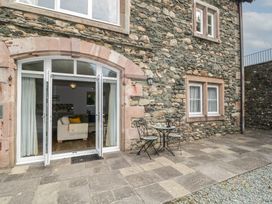 An outdoor seating area with stone wall at High Spy in Keswick
