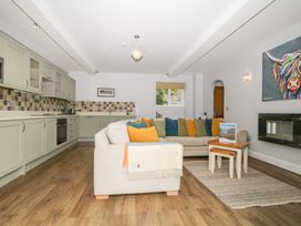 A living room with a kitchen area and sofa at High Spy in Keswick