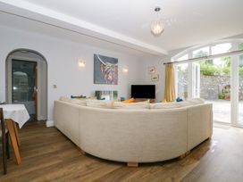 A living room with a sofa, TV, and painting at High Spy in Keswick