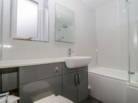 A bathroom with a bathtub, sink, and mirror at High Spy, Keswick
