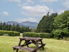 A picnic table on grass with mountains in the background at High Spy in Keswick