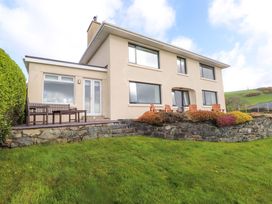 A house with a patio and furniture at Bryn Deryn in Criccieth