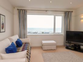 A living room with a sofa and TV at Bryn Deryn in Criccieth