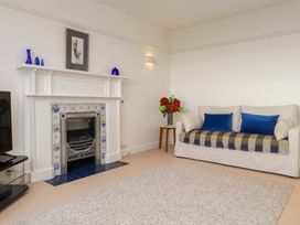 A living room with a fireplace and a sofa at Bryn Deryn in Criccieth