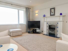 A living room with a television and a fireplace at Bryn Deryn in Criccieth