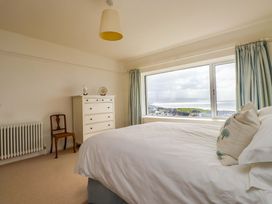 A bedroom with a bed and dresser at Bryn Deryn in Criccieth