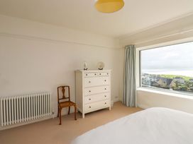 A bedroom with a dresser and a chair at Bryn Deryn in Criccieth
