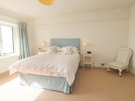 A bedroom with a bed and nightstand at Bryn Deryn in Criccieth