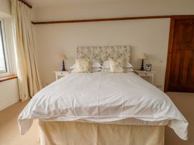 A bedroom with a bed and bedside table at Bryn Deryn in Criccieth