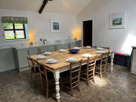 A dining room with a large table and chairs at Bryn Eira Stables in Llanfair PG