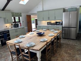 A kitchen with a wooden dining table and refrigerator at Bryn Eira Stables in Llanfair PG