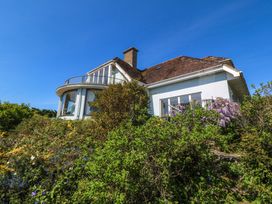 A house with a balcony surrounded by greenery at Bryn Y Mor, Borth Y Gest
